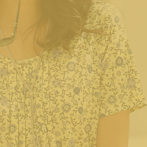 Woman wearing a floral yellow top.