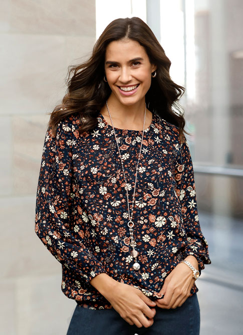 Woman wearing the navy-blue-brown-printed flowy floral blouse.