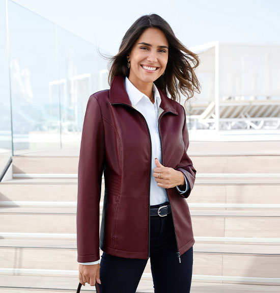 Woman wearing a soft faux-leather jacket in bordeaux.