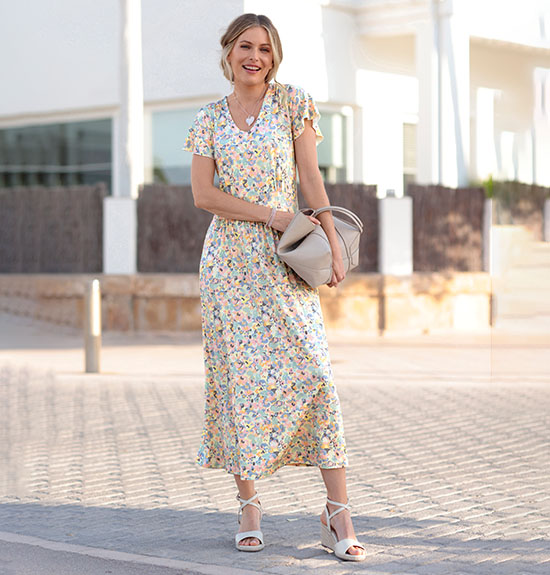 Woman wearing the champagne-printed floral maxi dress.