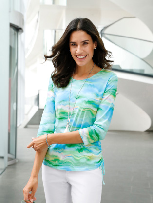 Woman wearing a watercolor print blouse.