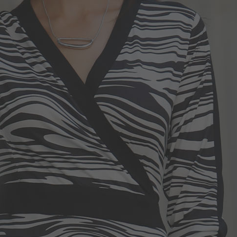 Woman wearing a black and white, zerba print dress.
