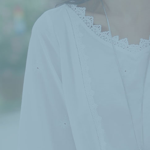 Woman weaing white blouse with lace detail.