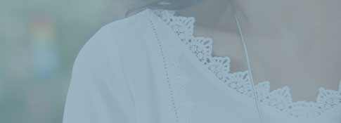 Woman weaing white blou
																											 se with lace detail.