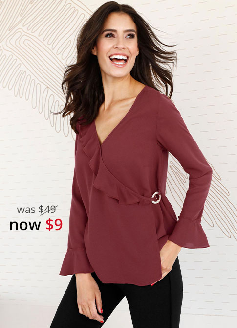 Woman wearing a ruffle wrap blouse in red.