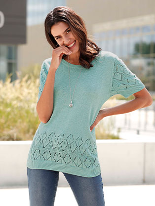 Woman wearing the ocean-mottled patterned short sleeve sweater.