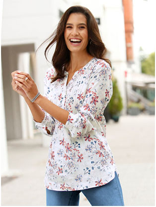 Woman wearing a long sleeve linen blouse in a light rose and blue pattern.